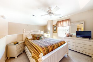 Cozy retreat with a single bed, nightstand, dresser, and TV.