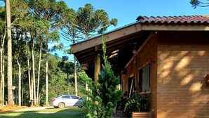 A house with a gravel driveway, a lawn, and a car parked in the background. - Sopro da Serra (Gonçalves)