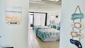 Une chambre avec un lit, une pancarte de bienvenue et une décoration sur le thème de la plage.