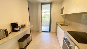 A modern kitchen with a built-in oven, a sink, and a coffee maker. - Nuevo, con Grande Terraza, a 200 m de la Playa y 500m del Puerto y Centro (Cambrils)