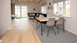 Un comedor moderno con una mesa de madera, sillas y un tapete estampado.