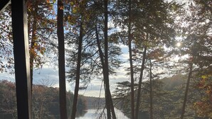 A hot tub with a view of a forest and a lake. - Burnt Mountain Waterfront Log Cabin, with 6person Spa  (Big Canoe)