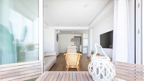 An open-plan living area with a wooden table, wicker chairs, and a white lantern. - A&n Santa Fé       . (Torre del Mar)