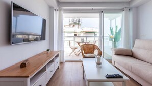 A modern living room with a flat-screen TV, wooden coffee table, and a sofa. - A&n Santa Fé       . (Torre del Mar)