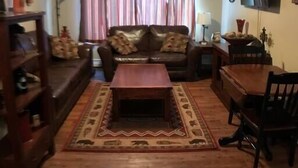Ein Wohnzimmer mit einer Couch, einem Couchtisch und einem Esstisch.