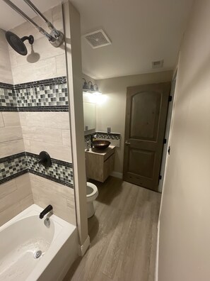 A bathroom with a bathtub, a sink, and a toilet.