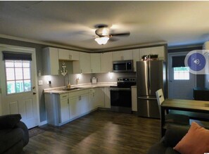 Enjoy cooking in this well-equipped kitchen with a central island, sink, oven, refrigerator, and microwave.