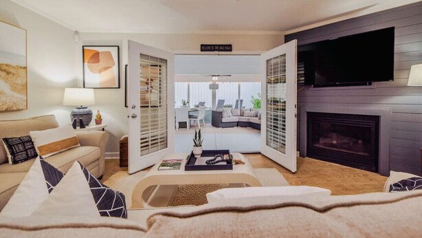 Een moderne woonkamer met een bank, salontafel en open haard.