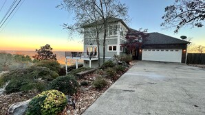 Une maison à deux étages avec un balcon, un garage et une vue sur le paysage.