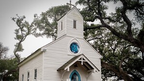 A white church with a blue door and a cross on top. - Round Top Hotel (Round Top)