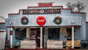 A vintage-style cafe with a Coca-Cola sign, decorated with wreaths and a neon sign. - Round Top Hotel (Round Top)