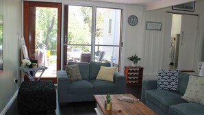 Un salon avec un canapé, une table basse et une petite table sur laquelle est posée une plante.