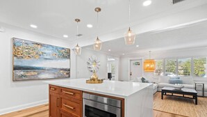 Een moderne keuken met een centraal eiland, houten kastjes en roestvrijstalen apparatuur.