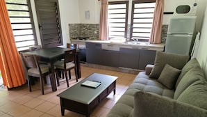 A compact living space with a kitchenette, dining area, and seating area. - Oasis de Kiamu (Lifou)