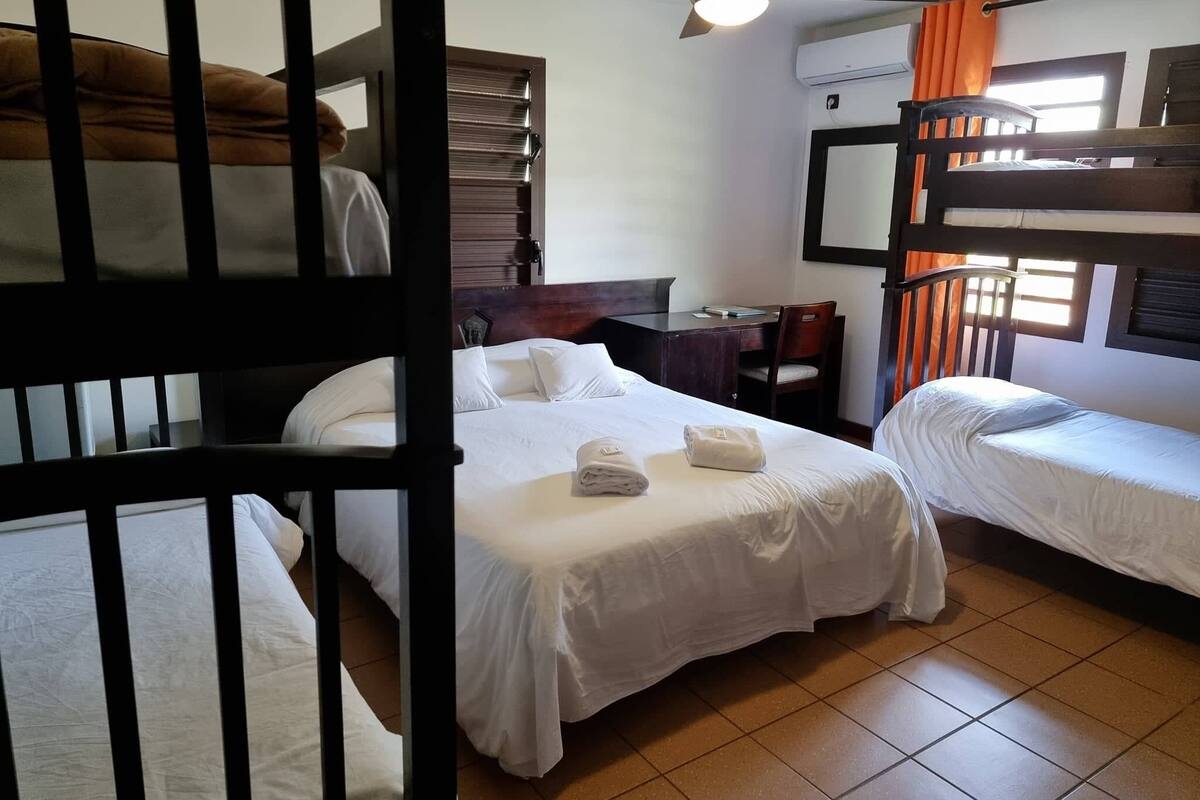 Un dormitorio con literas, un escritorio y una silla.