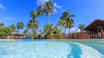 Una piscina al aire libre, sillones reclinables de piscina