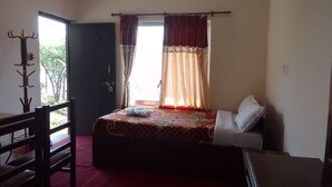 A bedroom with a bed, a chair, a coat rack, and a window with curtains. - Beautiful Lakeview rooms just 10 min by taxi from mainroad (Pokhara)