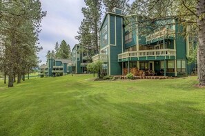 Enjoy outdoor dining or relaxation on the upper-level balcony overlooking a serene lawn and mature trees.