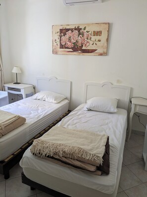 A hotel room with two single beds, a desk, a chair, a lamp, and a painting on the wall. - Spacious, air-conditioned villa with private pool and beach - 10 min. walk away (Agde)