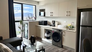 Een moderne keuken met een ingebouwde wasmachine en droger, een magnetron en een koelkast.