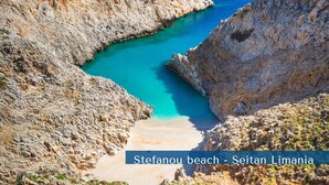 Paesaggio costiero con spiaggia e scogliere rocciose.
