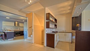 Una cucina moderna con isola centrale, elettrodomestici integrati e zona pranzo con bancone.