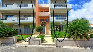 A modern two-story building with balconies, a central entrance, and a small garden area. - Cabanavillas Rio - Holiday Villa rental with pool in Agia Marina, Crete (Agia Marina)