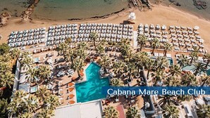 An aerial view of a beach resort with rows of sun loungers and a swimming pool. - Cabanavillas Casablanca - Holiday villa with pool in Agia Marina, Crete (Agia Marina)