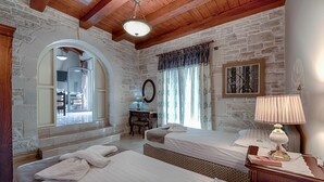 Una habitación con dos camas, un escritorio, una lámpara y un cuadro en la pared.