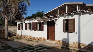 A white building with a tiled roof, stone foundation, and wooden shutters. - Air-conditioned villa - Sea m. 300 (beach) between NOTO-AVOLA (Sr)  (Avola)