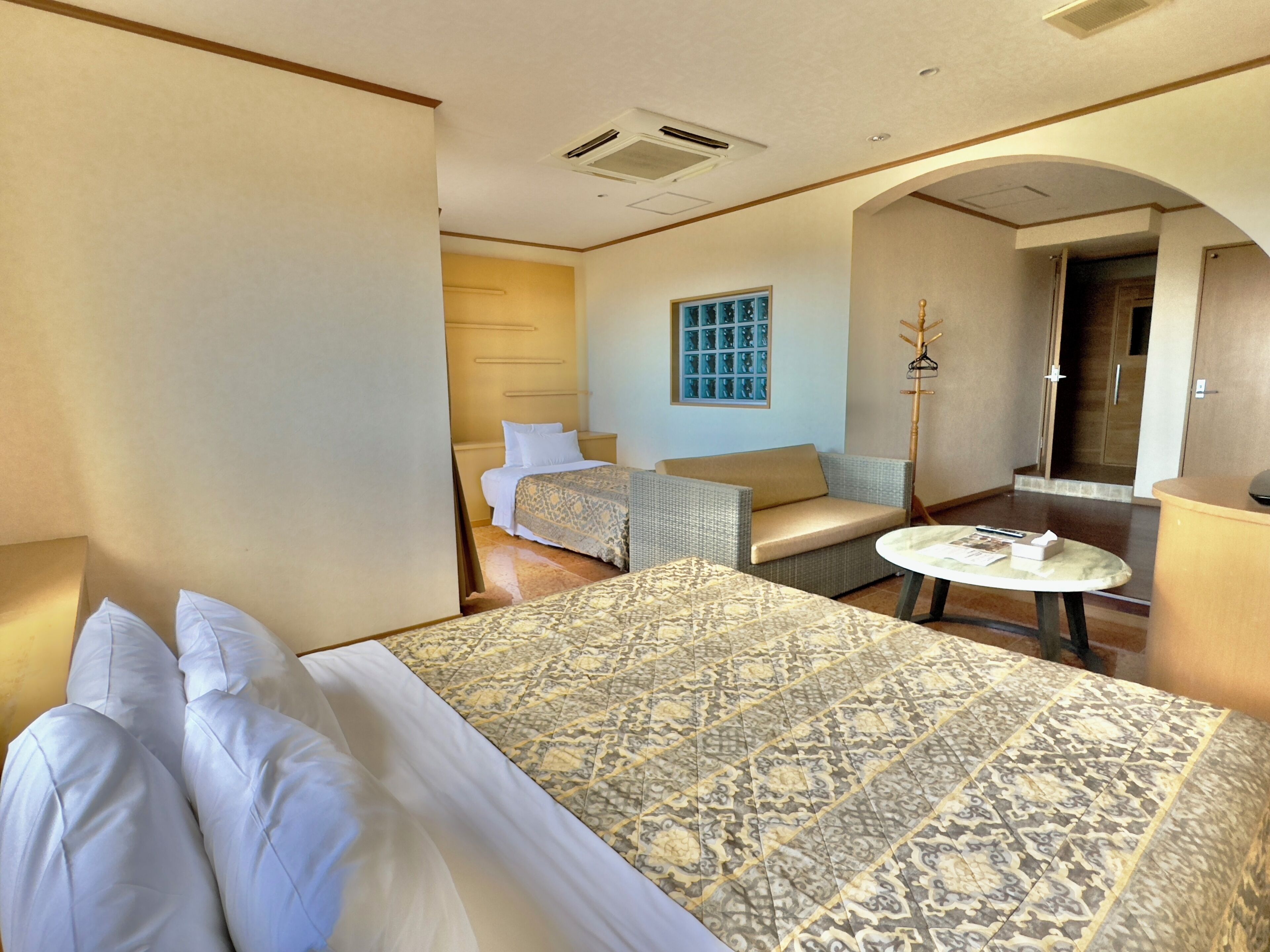 Una habitación de hotel con una cama grande, un sofá, una mesita y una ventana con vistas.