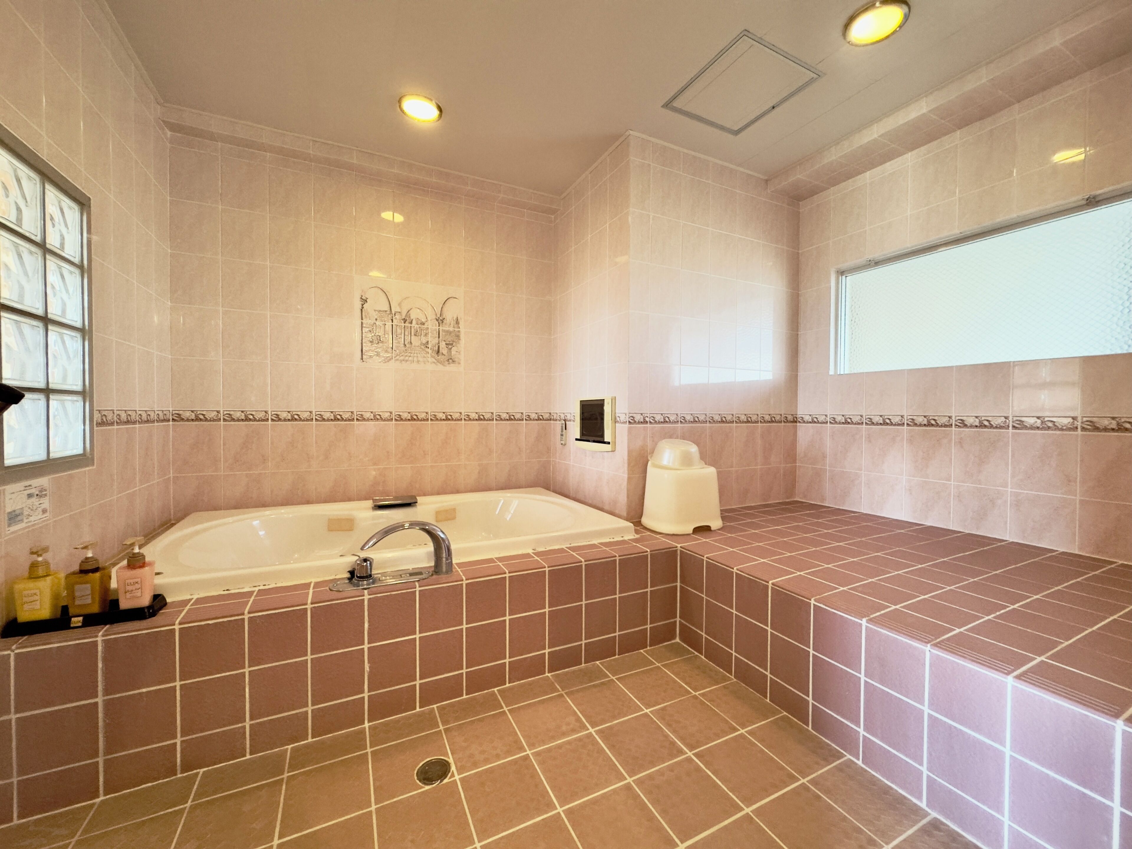 A bathroom with a bathtub, a toilet, and a shower area.