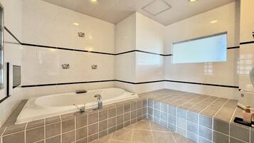A modern bathroom with a freestanding bathtub, a shower area, and a vanity with a mirror.
