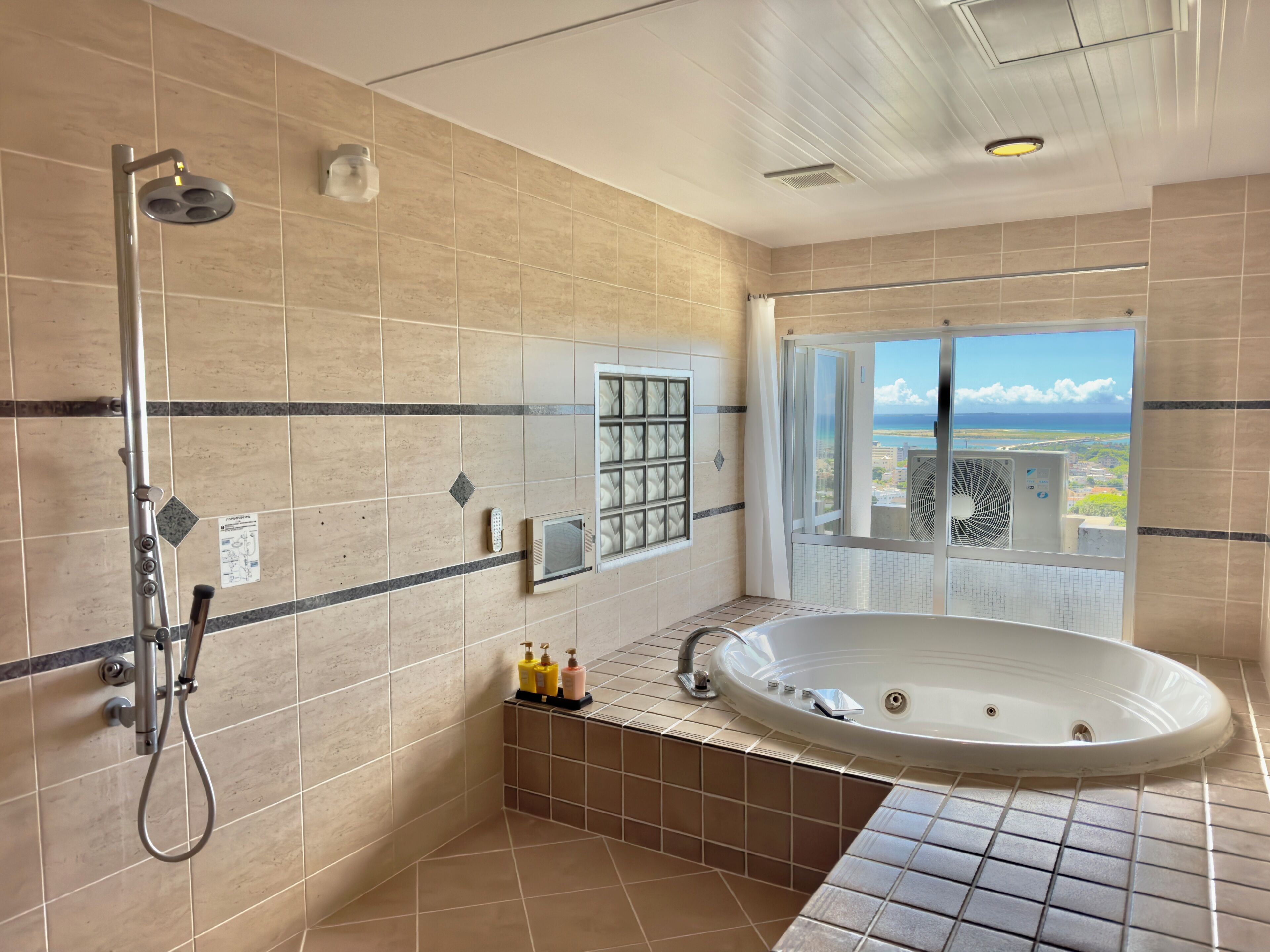 A modern bathroom with a bathtub, shower, and a view of the city.