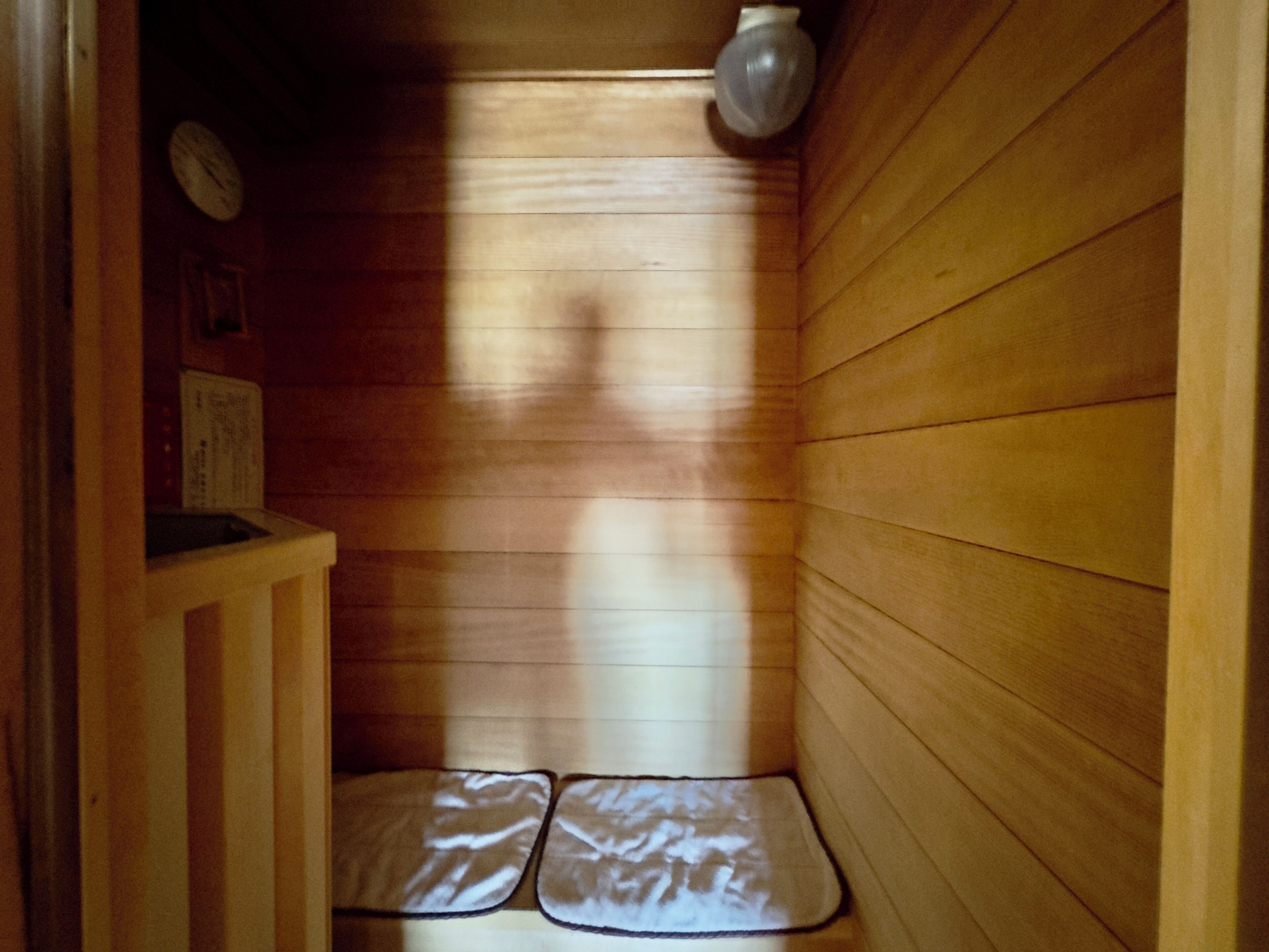 A sauna room with wooden walls and a bench.