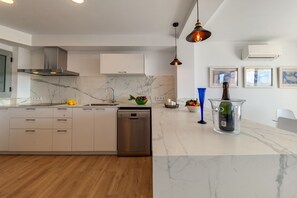Enjoy cooking in this kitchen with a central island, stainless steel appliances, and a backsplash.