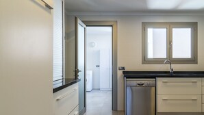 A modern kitchen with a dishwasher, a sink, and a window above the countertop. - Apartment Cormes By SunVillas Mallorca (Puerto Pollença)