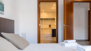 A bedroom with a bed, pillows, and neatly folded towels. - Apartment Cormes By SunVillas Mallorca (Puerto Pollença)