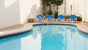 A swimming pool with blue tiles, surrounded by white walls and blue lounge chairs. - Apartment Voltor 2 E By SunVillas Mallorca (Puerto Pollença)