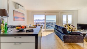 Una sala de estar moderna con un sofá, un televisor y un comedor con una mesa y sillas.