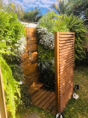 A wooden garden shower enclosure surrounded by lush greenery. - IPOMEA waterfront bungalow on the lagoon La Saline les Bains (La Saline les Bains)