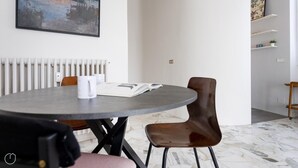 A modern dining area with a round table, two chairs, a book, and a mug. - Italianway Easy - Sirte 6 (Milan)