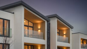 Ein modernes Mehrfamilienhaus mit Balkonen und großen Fenstern.