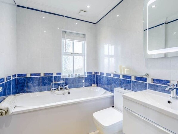 Une salle de bain moderne avec une baignoire, des toilettes et un lavabo.