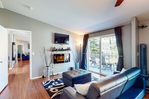 Relax in a stylish living room with a large flat-screen TV, fireplace, and comfortable seating area.