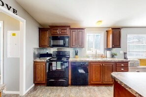 Enjoy cooking in this well-equipped kitchen with a central island, microwave, and stainless steel appliances.