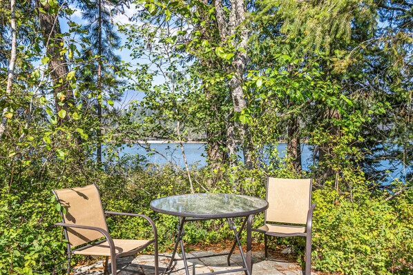 Relax in a serene outdoor setting surrounded by lush greenery and a tranquil body of water.