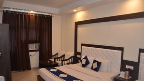 Habitación de hotel con una cama grande, dos mesitas de noche, un escritorio y una silla.