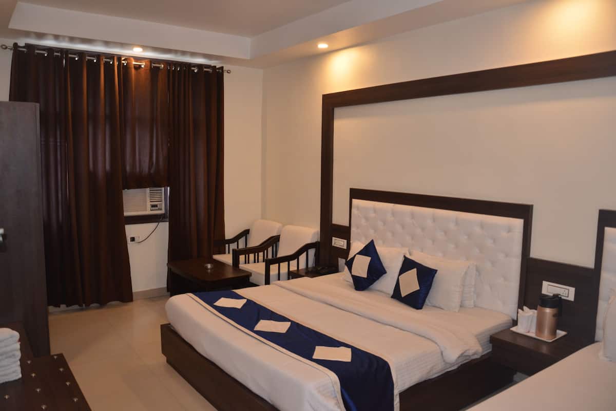 Habitación de hotel con una cama grande, dos mesitas de noche, un escritorio y una silla.