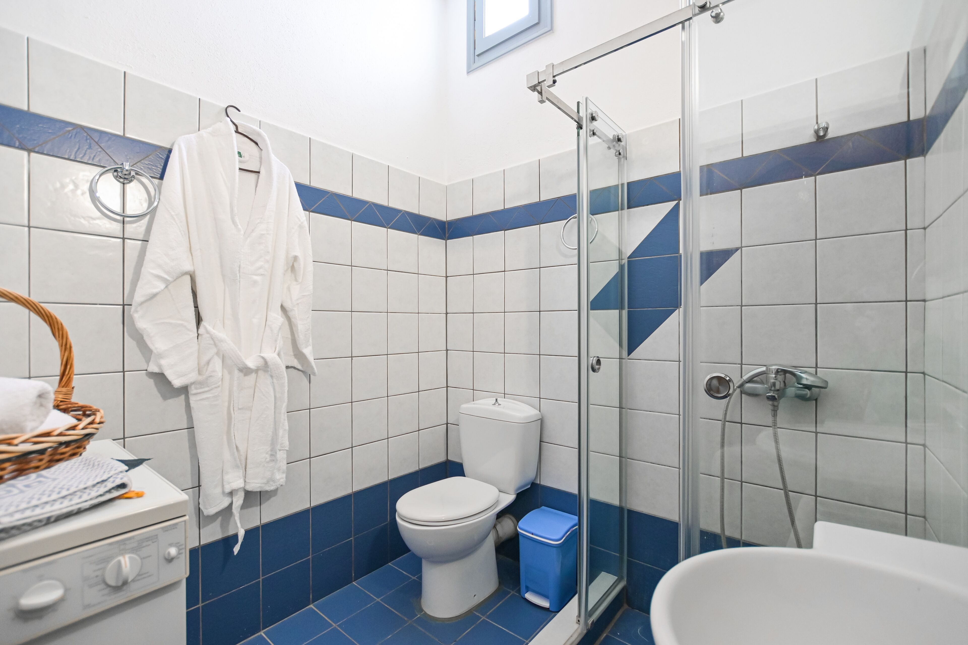 A bathroom with a toilet, shower, and a sink.